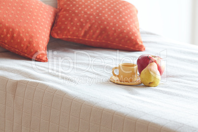 cup of tea,apple and pear on the bed