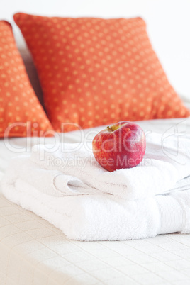 apple and white towels on the bed