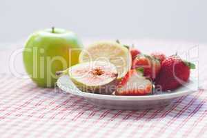 apple, lemon, fig and strawberries on a plate