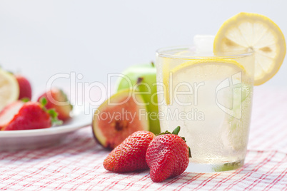 cocktail with ice,lemon, fig and strawberries on a plate