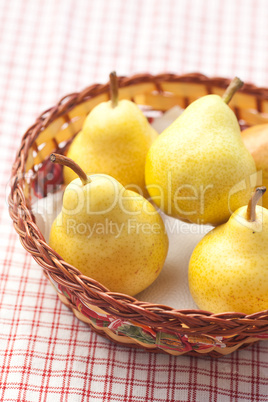 pears in a wooden basket  lying on a plaid fabric