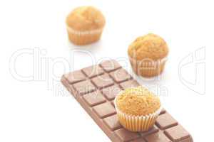 bar of dark chocolate and muffin isolated on white
