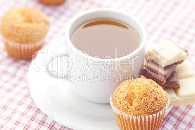 bar of chocolate,tea and muffin on plaid fabric