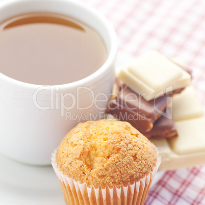 bar of chocolate,tea and muffin on plaid fabric