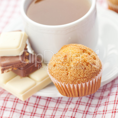 bar of chocolate,tea and muffin on plaid fabric