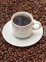 Cup with Hot Coffee on Coffee Beans