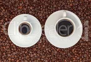 Cups with Hot Coffee on Coffee Beans