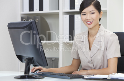 Asian Chinese Woman or Businesswoman Using Computer In Office