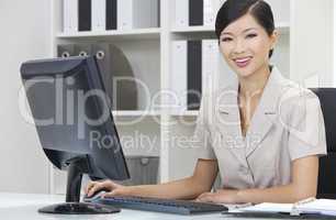 Asian Chinese Woman or Businesswoman Using Computer In Office