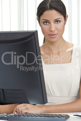 Hispanic Latina Woman or Businesswoman in Office Using Computer