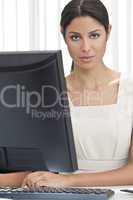 Hispanic Latina Woman or Businesswoman in Office Using Computer