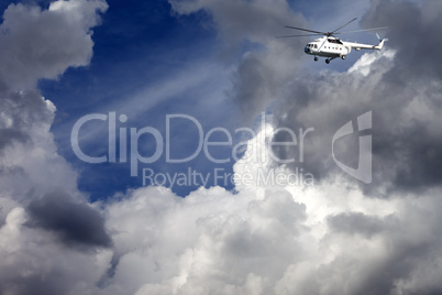 Helicopter in blue sky with clouds