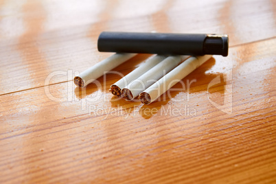 Cigarettes and lighter on wooden table