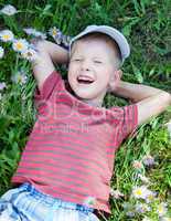 small boy lying on the grass