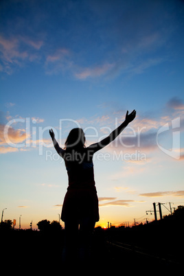 woman staying with raised hands