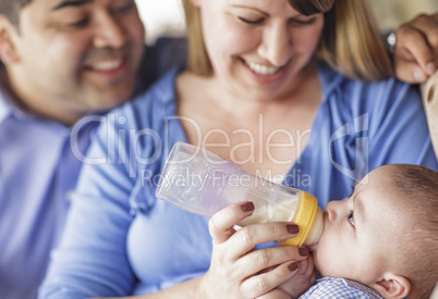 Happy Mixed Race Couple Bottle Feeding Their Son