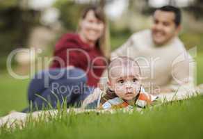 Happy Mixed Race Baby Boy and Parents Playing in Park
