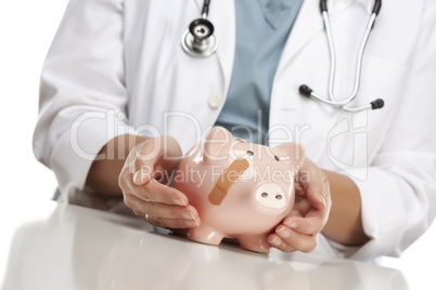 Doctor Holding Caring Hands on a Piggy Bank with Bandage