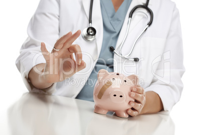 Doctor Gives Okay Sign Behind Piggy Bank