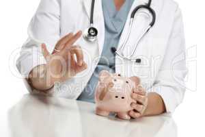Doctor Gives Okay Sign Behind Piggy Bank