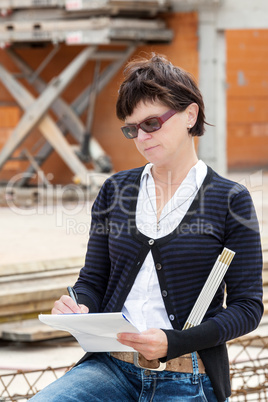 Woman makes the notes on the construction site