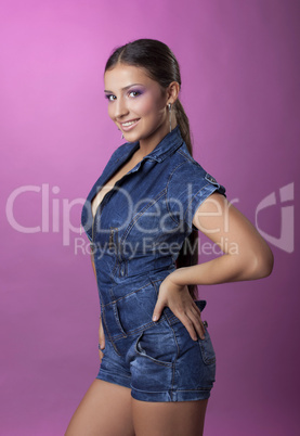 Smiling brunette young woman in denim overalls