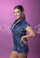 Smiling brunette young woman in denim overalls