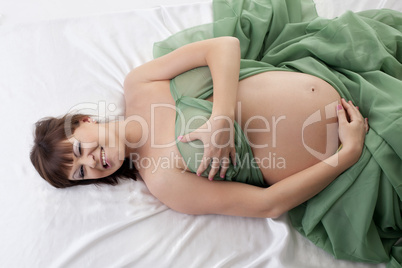 Happy pregnant woman lying in bed