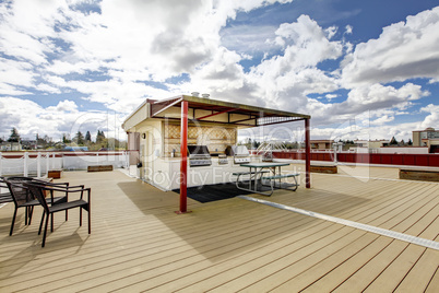 Apartment building roof top grill area with chairs.