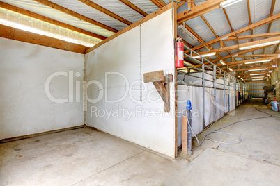 Horse arena interior with ashing area and stables.