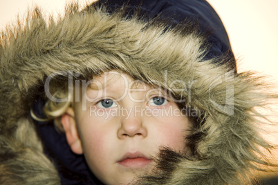 Little boy wearing a fur lined hood