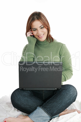 woman talking on mobile phone in front of laptop