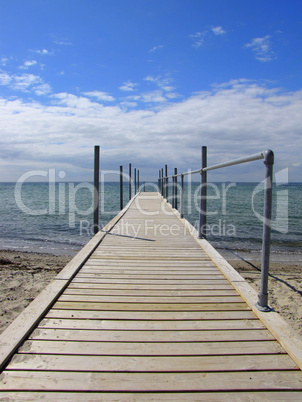 A wooden jetty goes into the beautiful blue sea