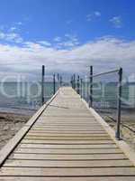 A wooden jetty goes into the beautiful blue sea