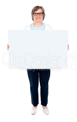 Smiling old lady holding blank whiteboard