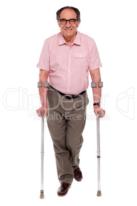 Smiling senior man walking with two crutches