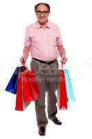 Happy matured man carrying shopping bags