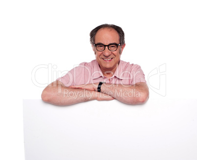 Matured man standing behind blank placard