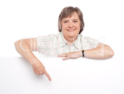 Attractive old woman indicating towards billboard