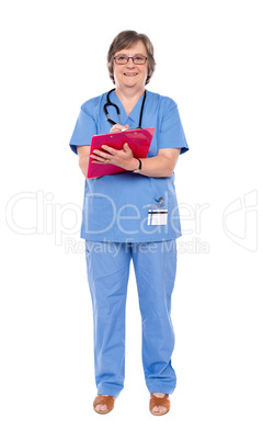 Senior female doctor writing on clipboard