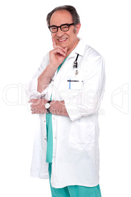 Senior male doctor posing against white