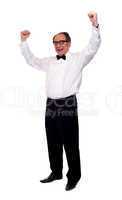 Excited senior man posing with raised arms