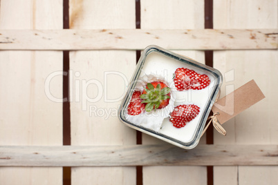 Strawberry falling into a container of milk