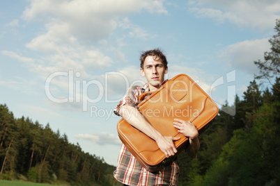 Young male tourist clutching his luggage
