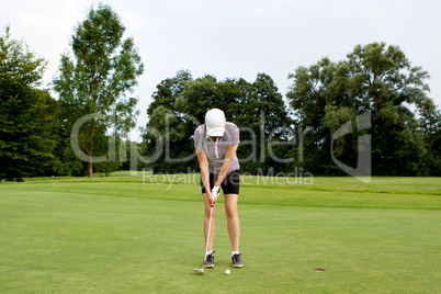 Frau spielt Golf auf einem Golfplatz