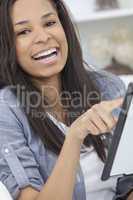 African American Woman Using Tablet Computer At Home