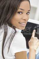 African American Woman Using Tablet Computer At Home