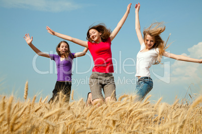 teen girl jumping at a wheat field