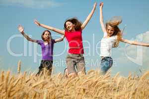 teen girl jumping at a wheat field