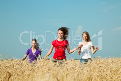 teen girls running at the wheat field